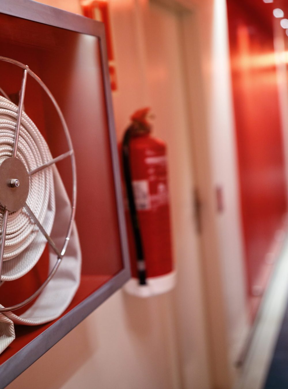 Fire extinguisher and fire hose reel in hotel corridor
